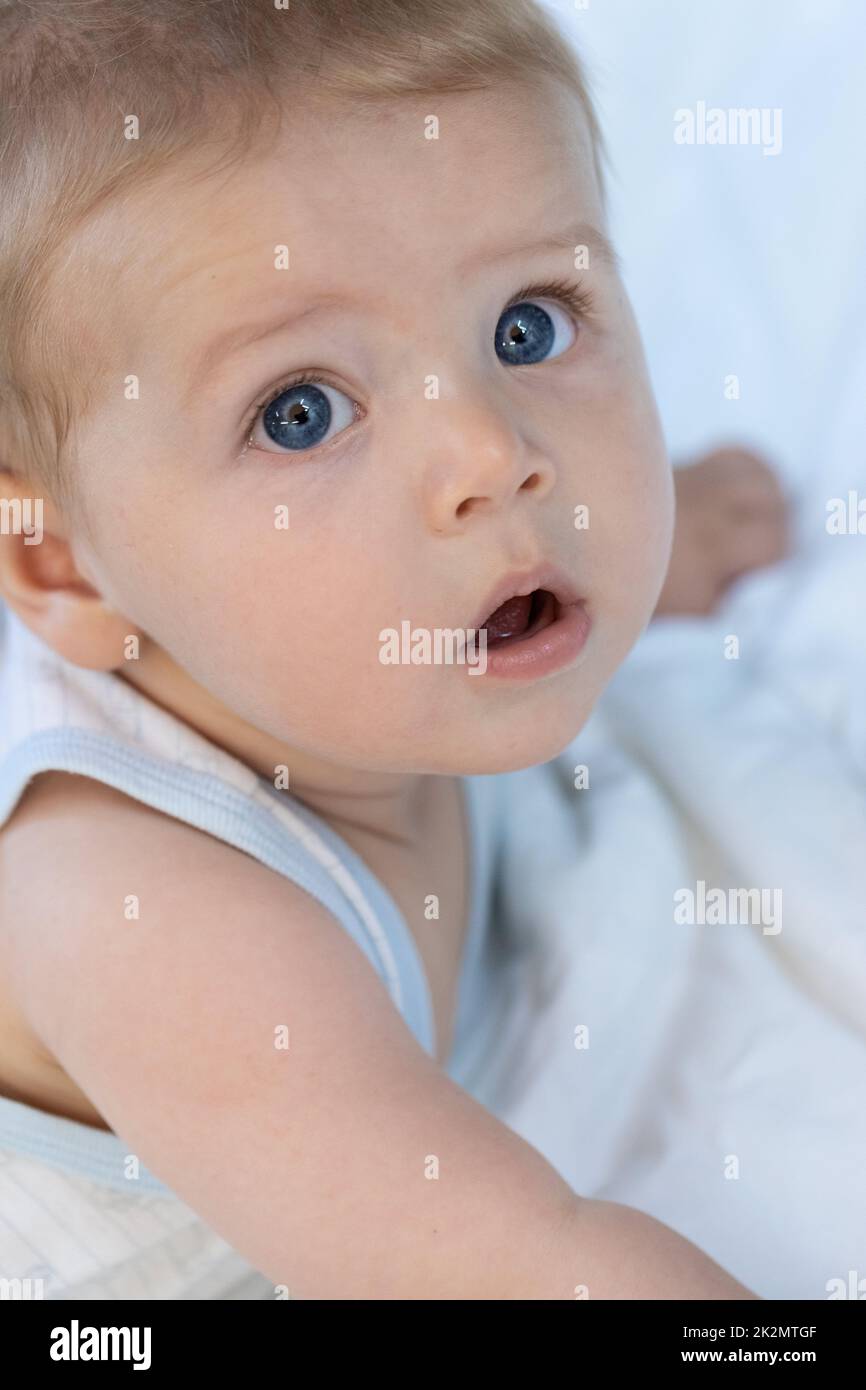 Thoughtful calm little blue eyed baby boy Stock Photo