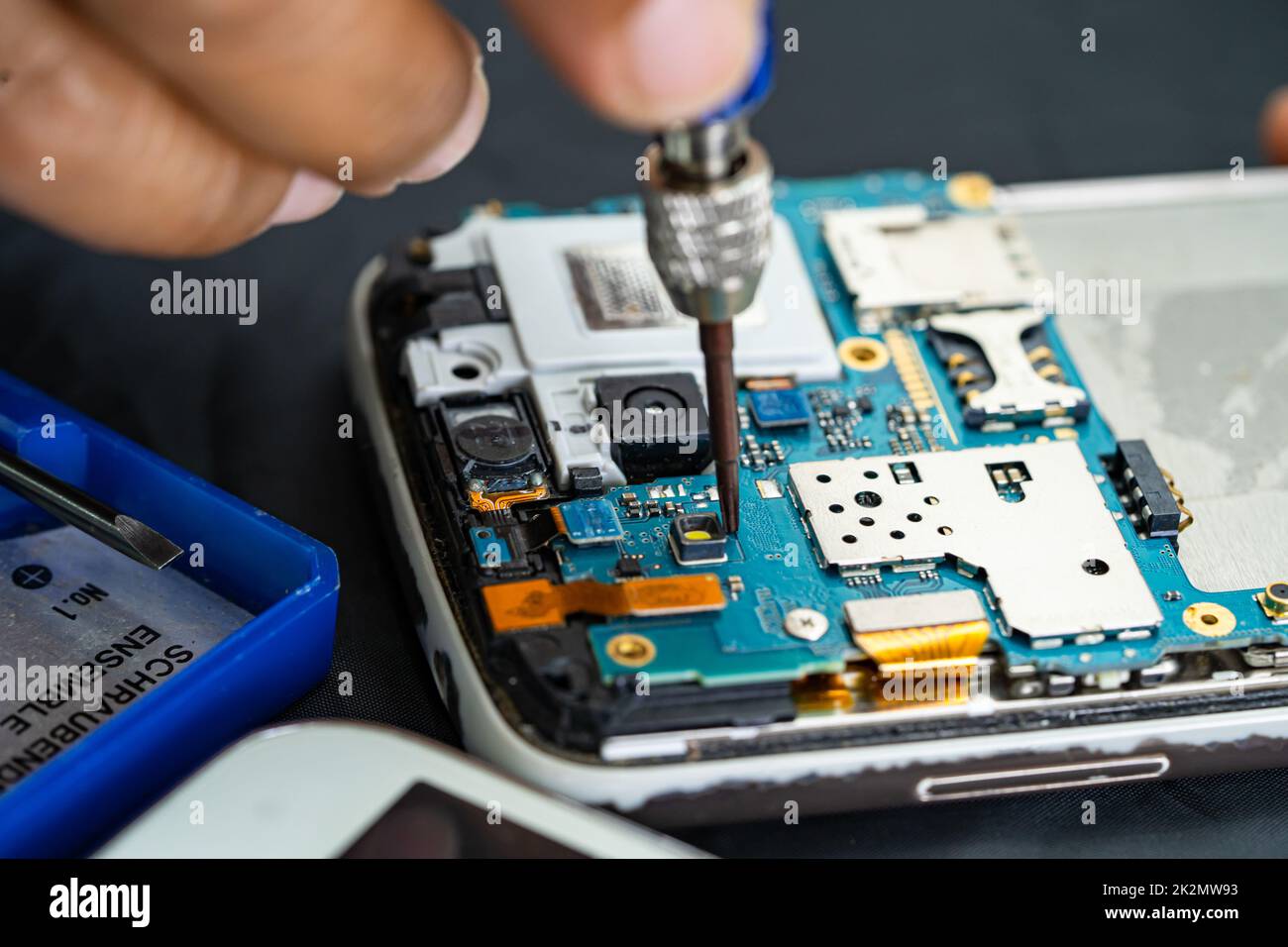 Technician repairing inside of mobile phone by soldering iron