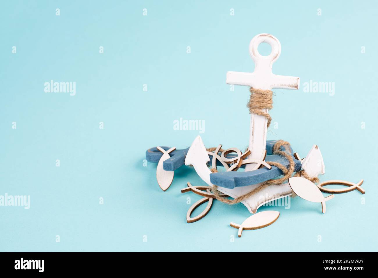 White anchor and fish on a blue background, maritime sea life, sailing trip, summer vacation, tourism concept, harbor Stock Photo