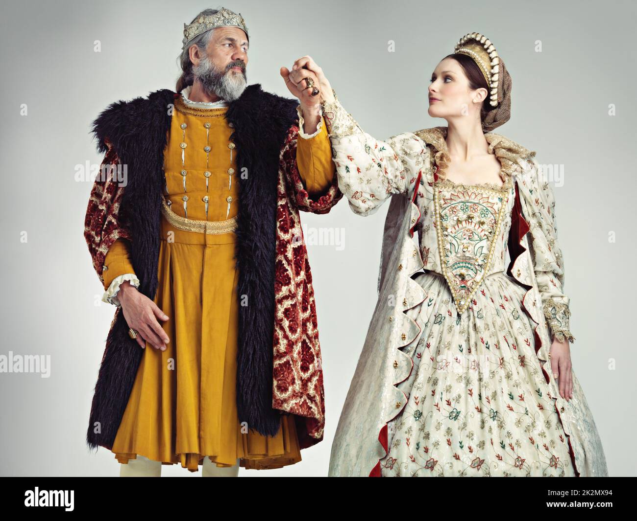 Royal affections. Studio portrait of a king and queen standing hand in hand. Stock Photo