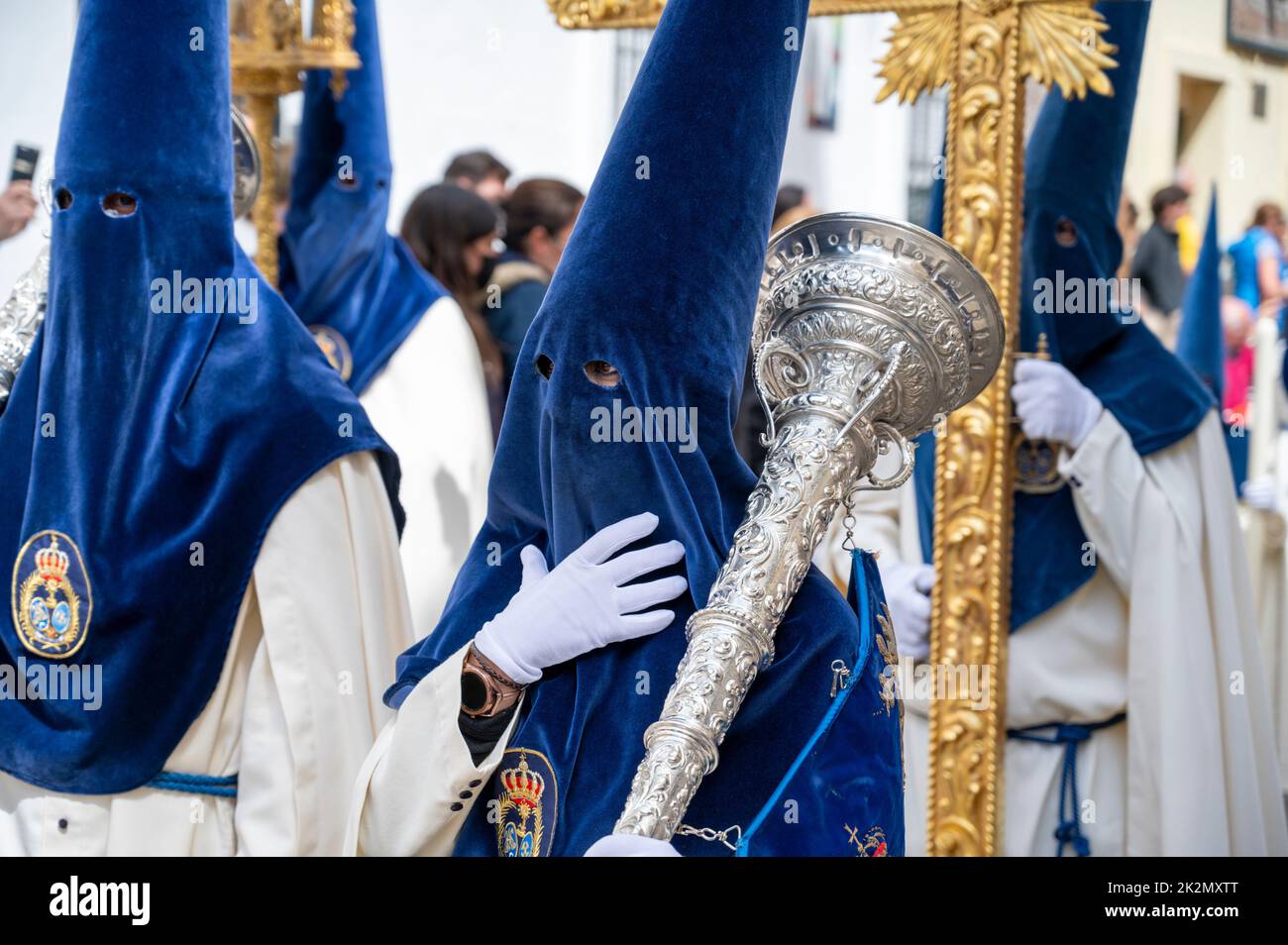 People wearing traditional capirote conical pointed hats in an easter parade in holy week in Cadiz Spain Stock Photo