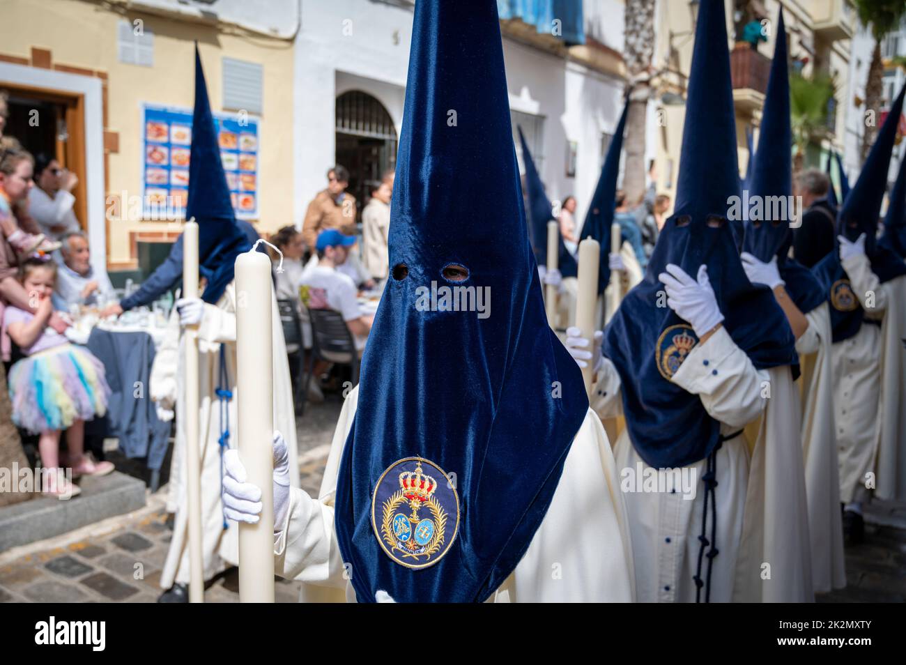 People wearing traditional capirote conical pointed hats in an easter parade in holy week in Cadiz Spain Stock Photo
