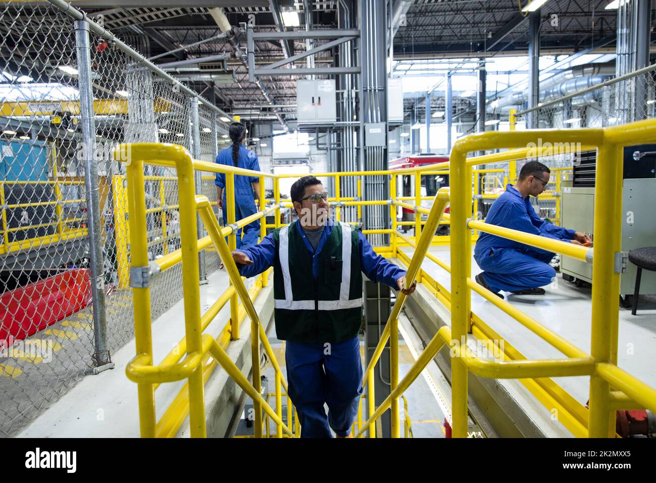 Male transit worker ascending steps in maintenance facility Stock Photo