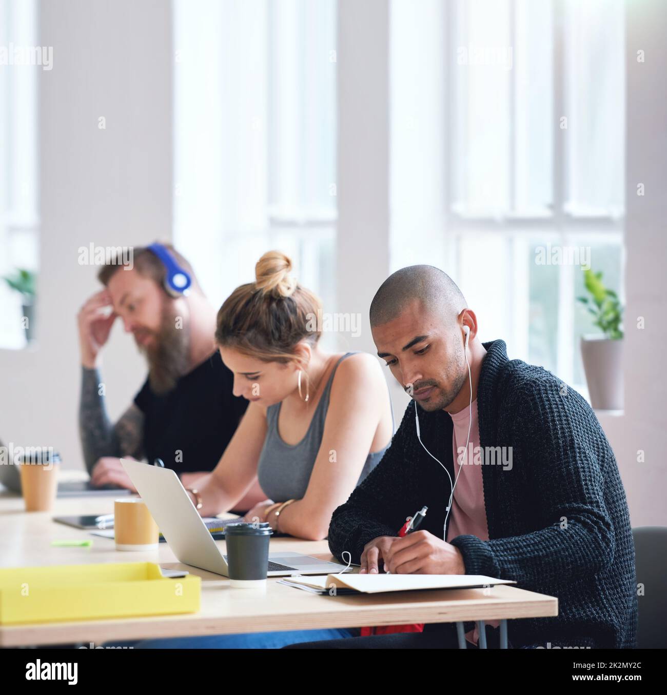 College students sitting at table in class working on project Stock Photo