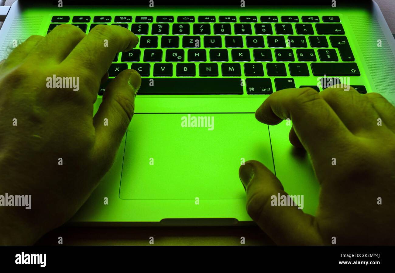 Typing with both hands on keyboard and using the touchpad on a laptop Stock Photo