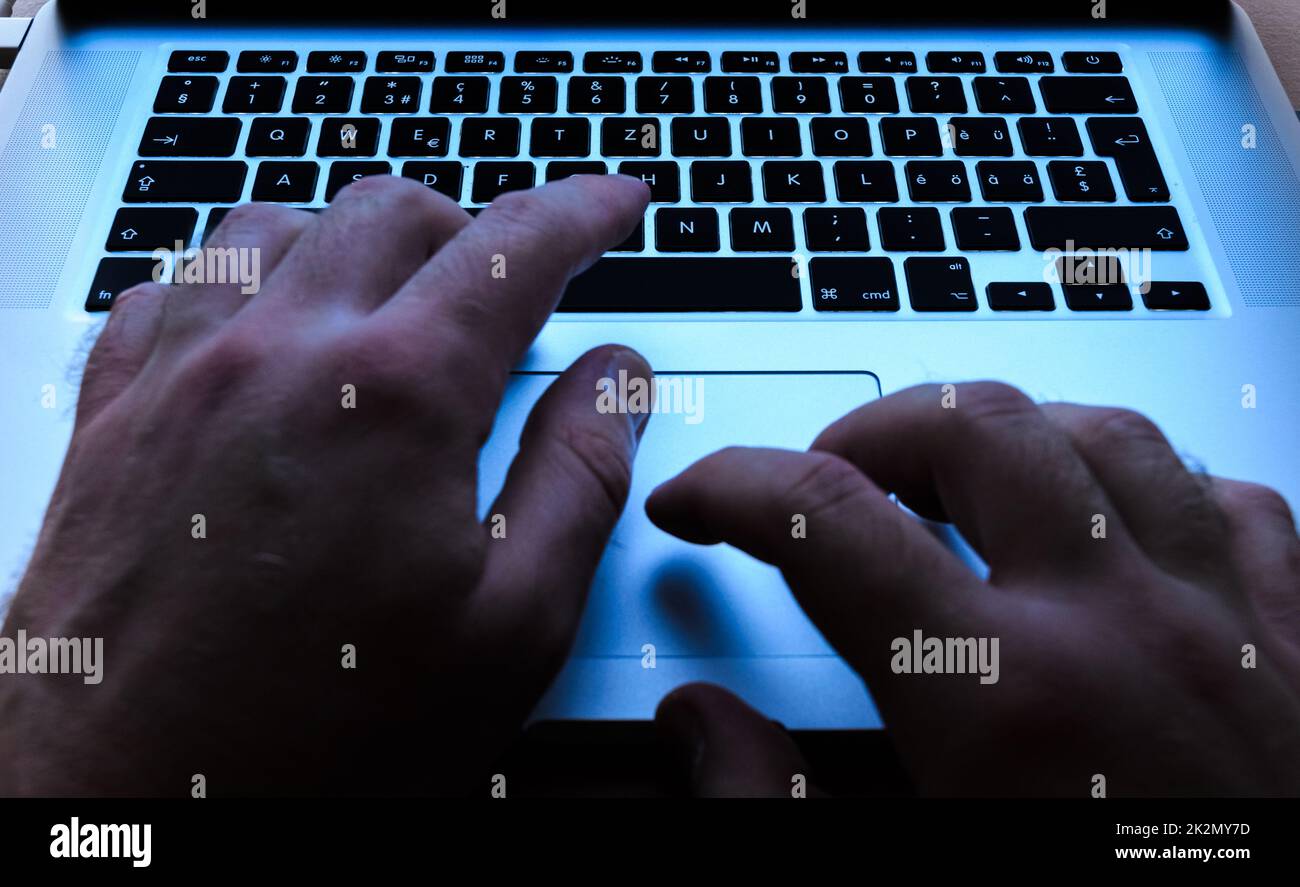 Typing with both hands on keyboard and using the touchpad on a laptop Stock Photo