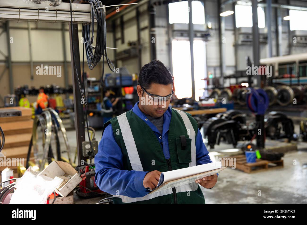 Male transit worker with clipboard in maintenance facility Stock Photo