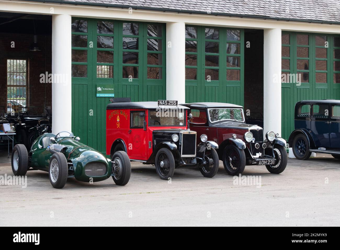 1933 Morris Royal Mail Van, 1934 Riley Saloon and a vintage sports car outside a workshop at Bicester Heritage Centre scramble event. Oxfordshire, UK Stock Photo