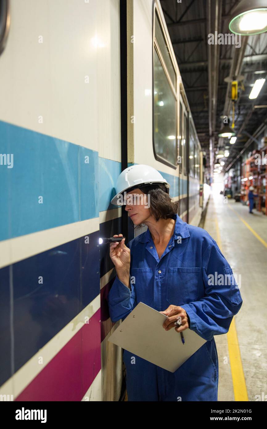 Female transit engineer with flashlight inspecting subway Stock Photo