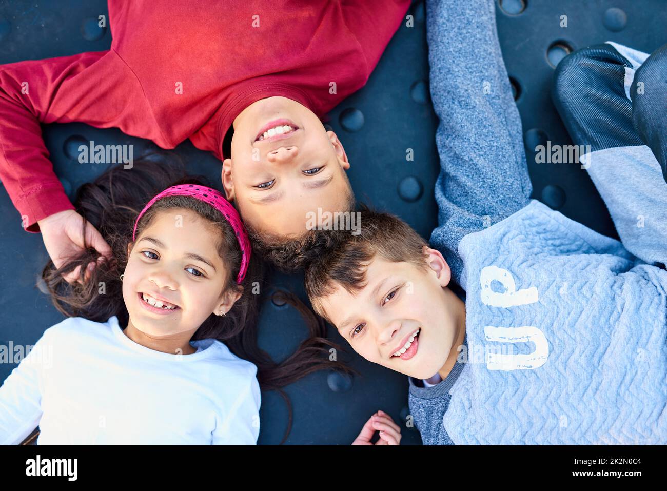 Childhood bliss. Portrait of three young siblings playing together at the park. Stock Photo