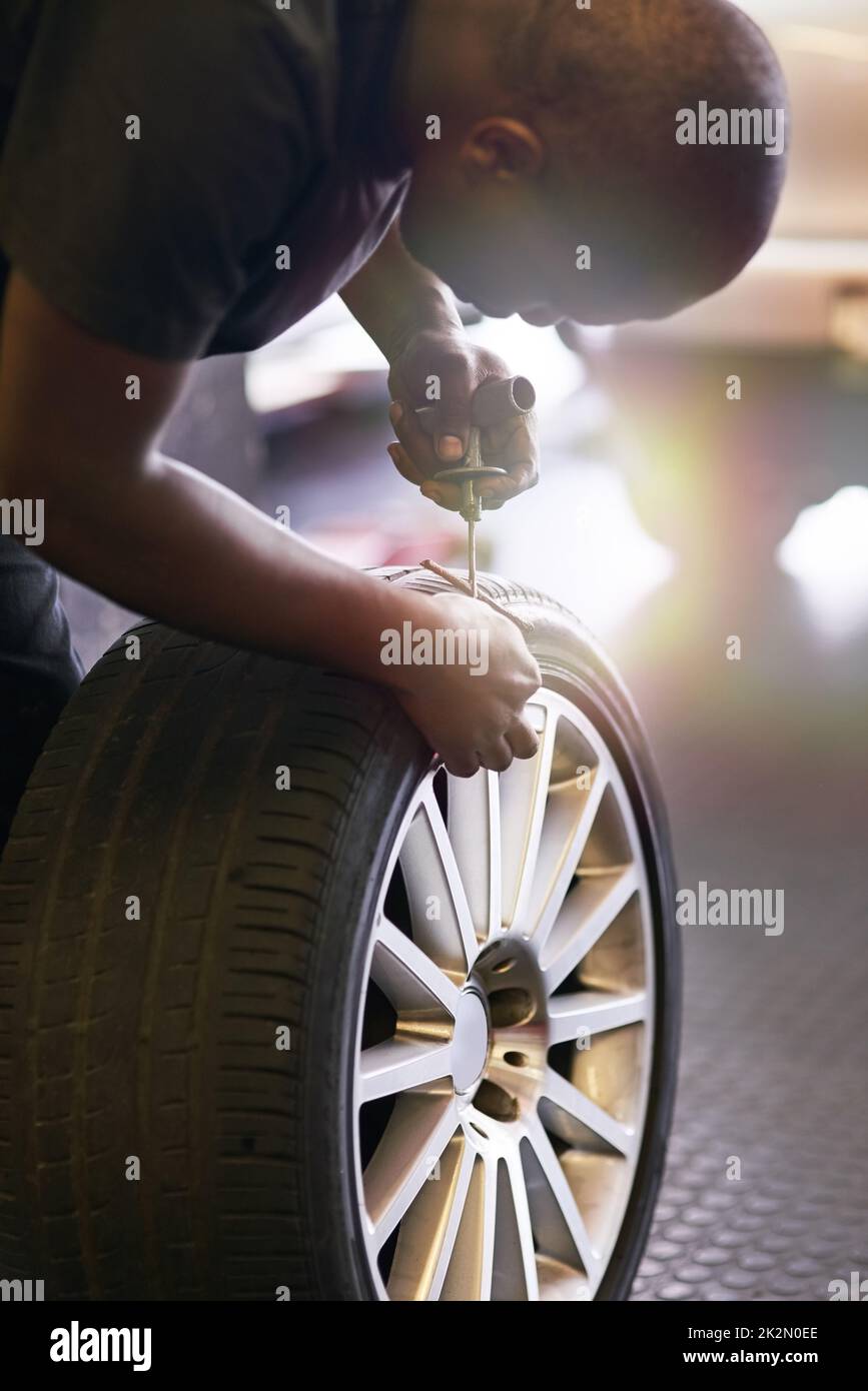 fixing-a-tyre-puncture-cropped-shot-of-a-mechanic-repairing-a-car-tyre-2K2N0EE.jpg