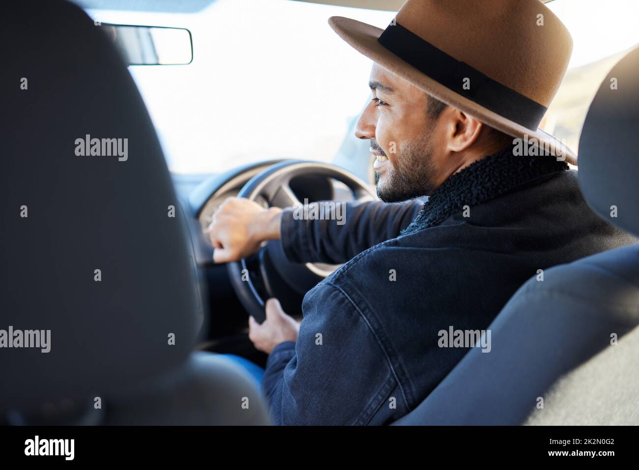 All he needed was a wheel in his hand. Shot of a young man driving his car. Stock Photo