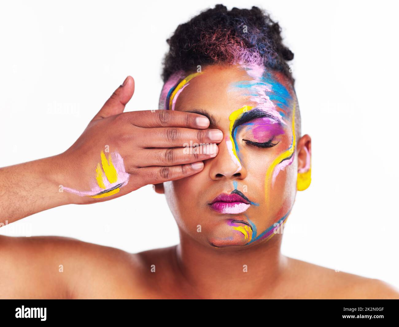 How you identify is your decision and no one elses. Cropped shot of a gender fluid young man wearing face paint against a white background. Stock Photo