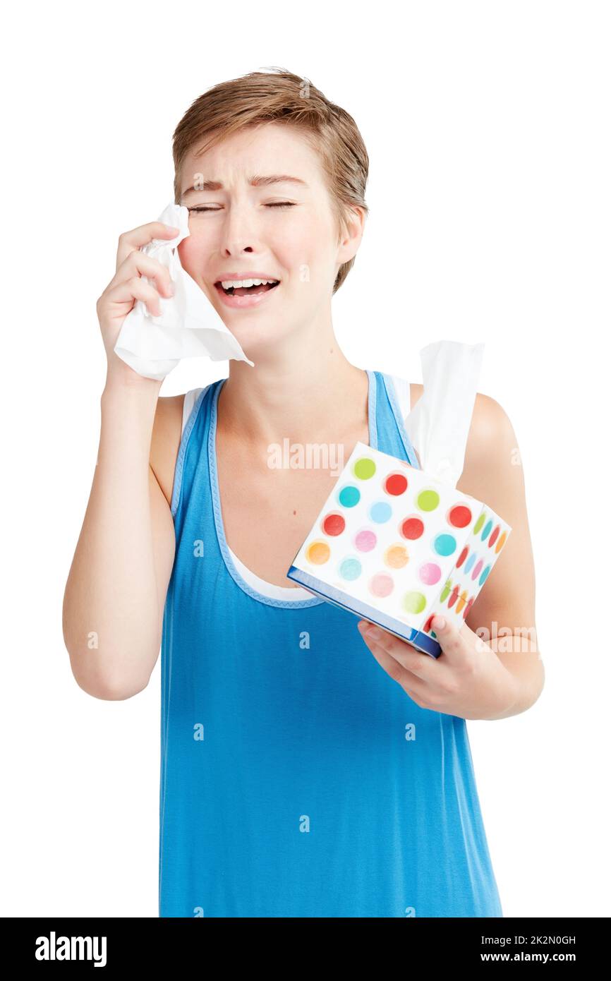 Thats so sad. Studio shot of a young woman wiping her tears. Stock Photo