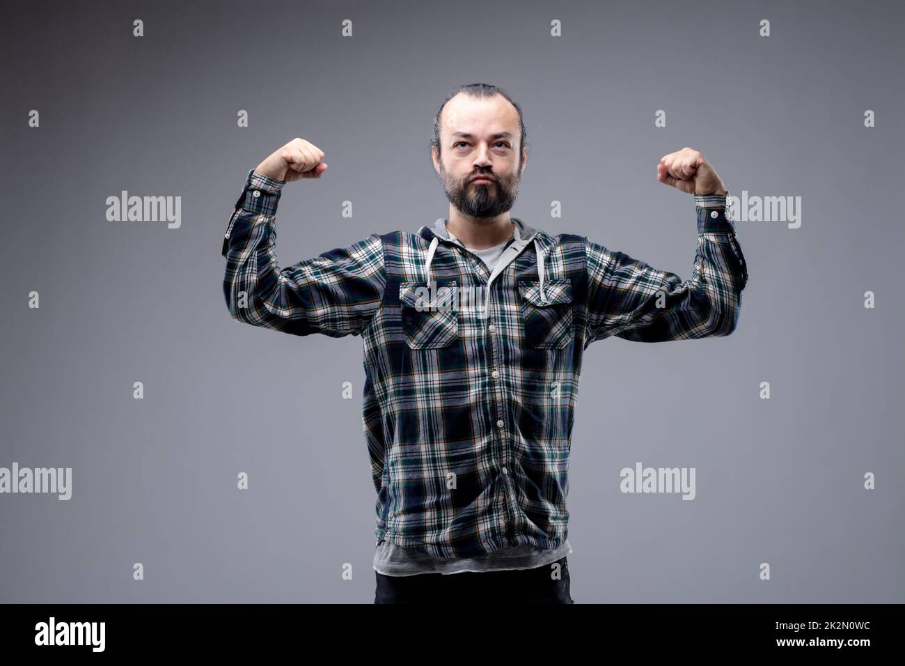Macho bearded man flexing his arms Stock Photo
