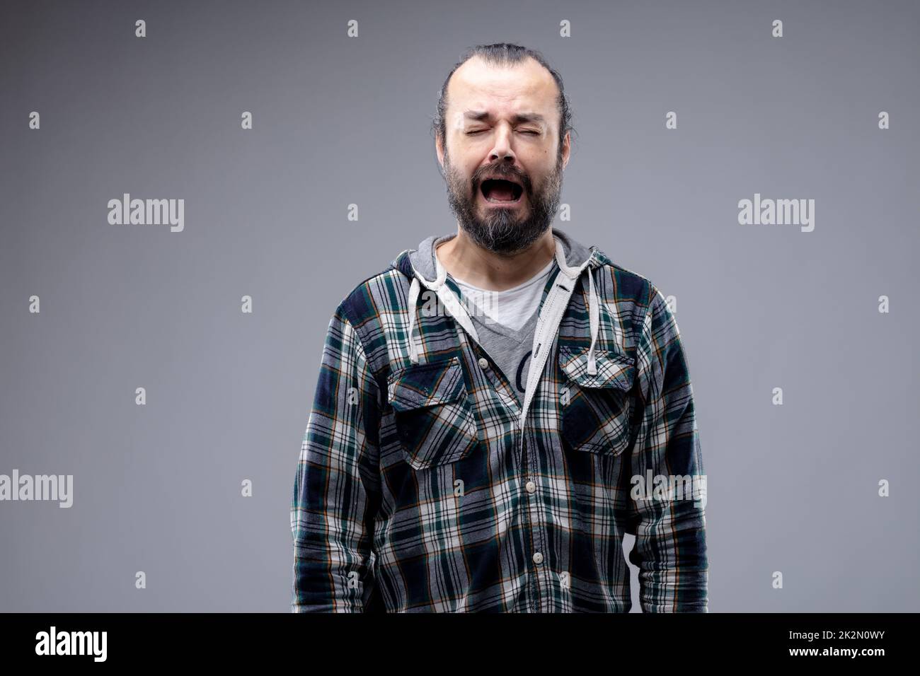 Miserable tearful man wailing and crying with a woeful expression and ...