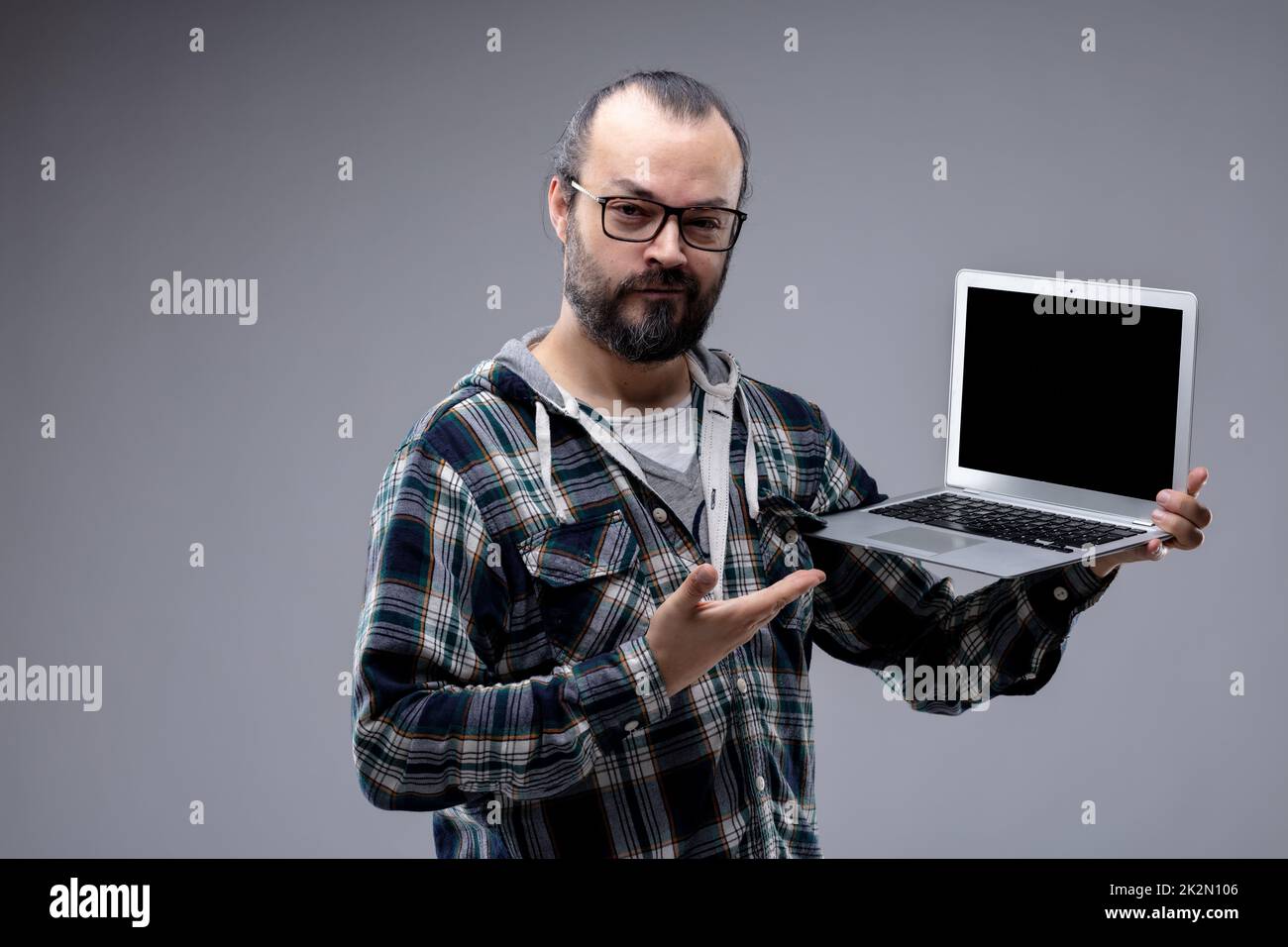 Pleased man pointing to his handheld laptop Stock Photo
