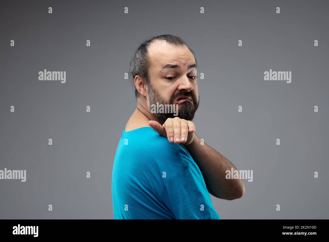 Man with grimace of disgust brushing shoulder Stock Photo