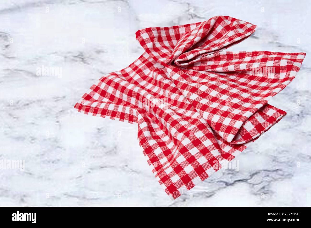 Empty table product. Top view of a abstract blurred marble top with a red and white checkered tablecloth or napkin. Template for your food and product display montage. Space for food recipe. Stock Photo