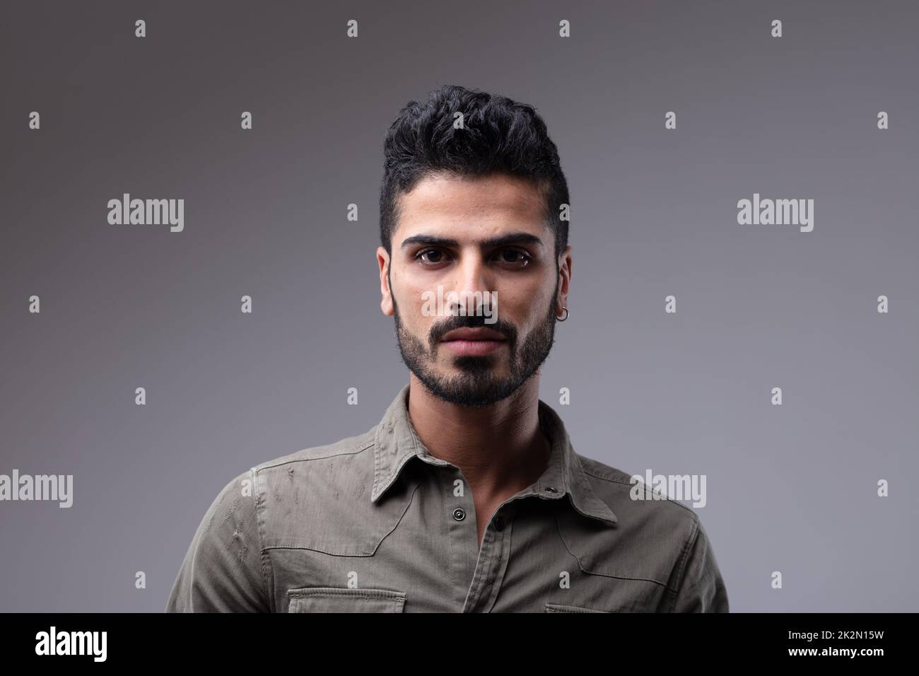 Young man with beard wearing grey button shirt Stock Photo
