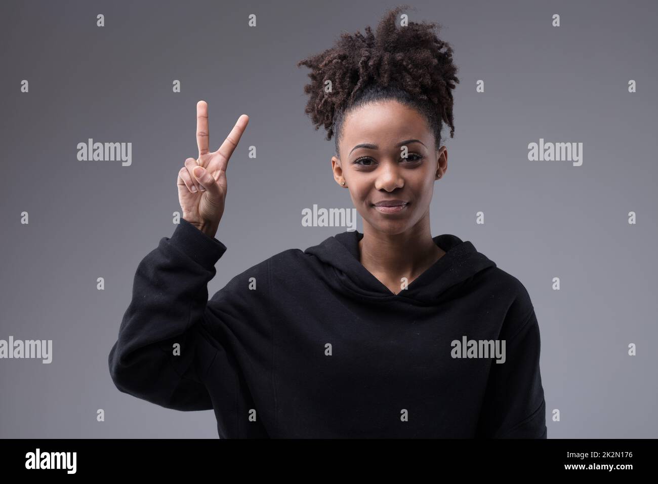 victory hand sigh made by a young beautiful smiling afroamerican woman with afro hairstyle Stock Photo