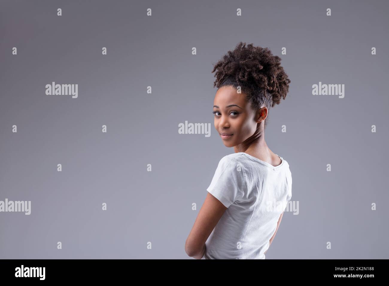 Young Black woman looking back at camera over her shoulder Stock Photo