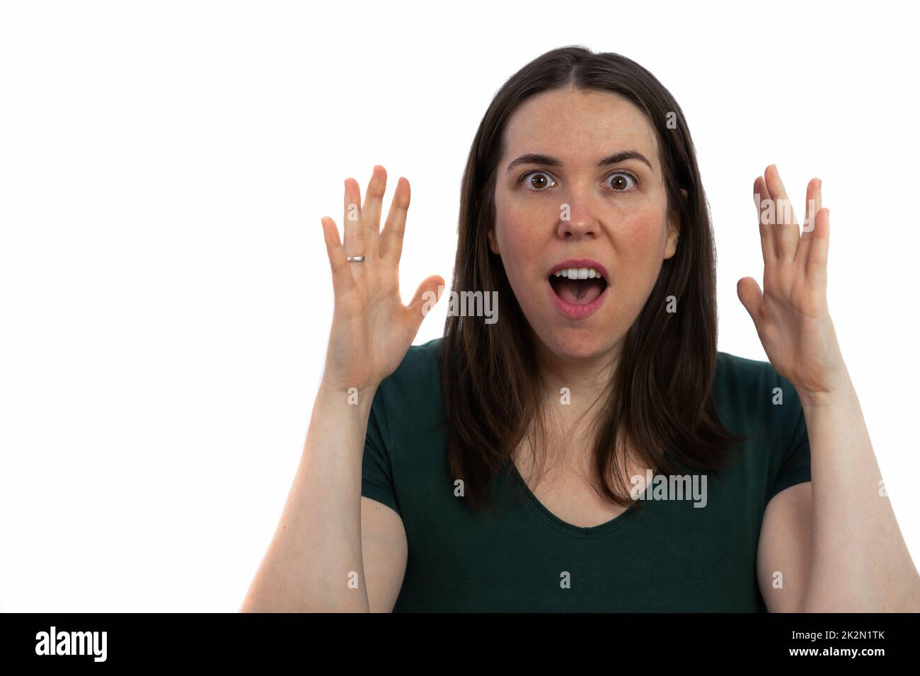 young brunette girl with a surprised expression with her hands in the air Stock Photo