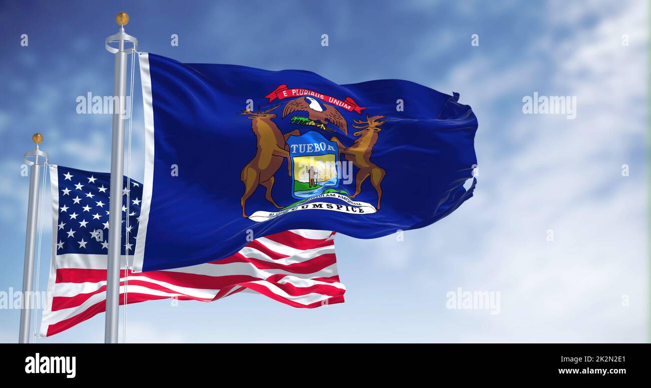 The Michigan state flag waving along with the national flag of the United States of America Stock Photo