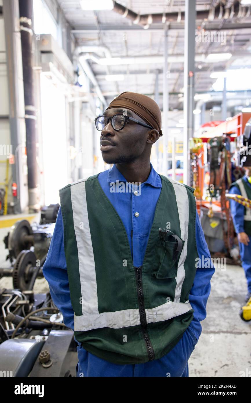 Portrait male transit engineer looking away in maintenance facility