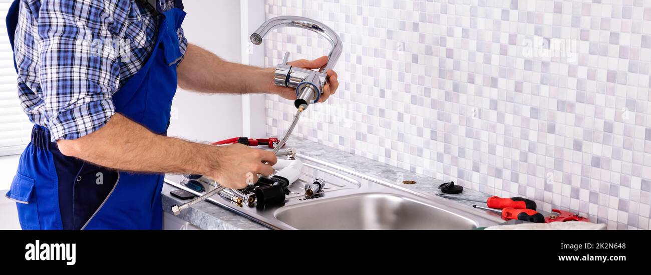 Plumber Assembling The Kitchen Sink Faucet Stock Photo