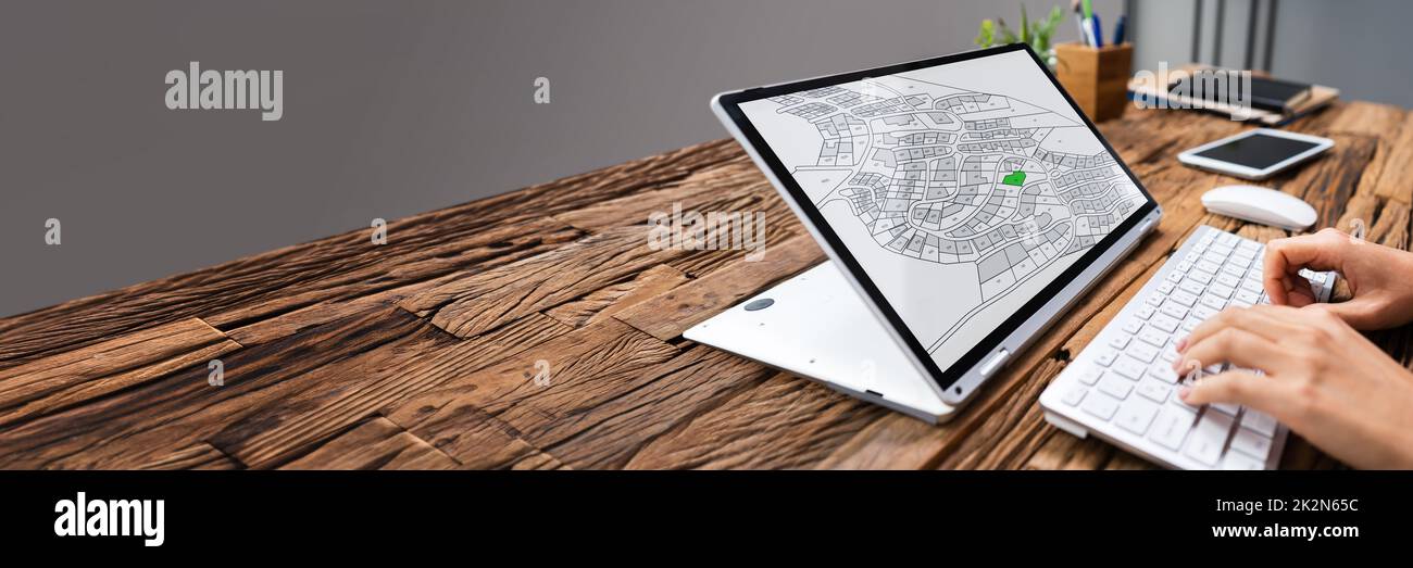 Businessperson Analyzing Cadastre Map On Computer Stock Photo
