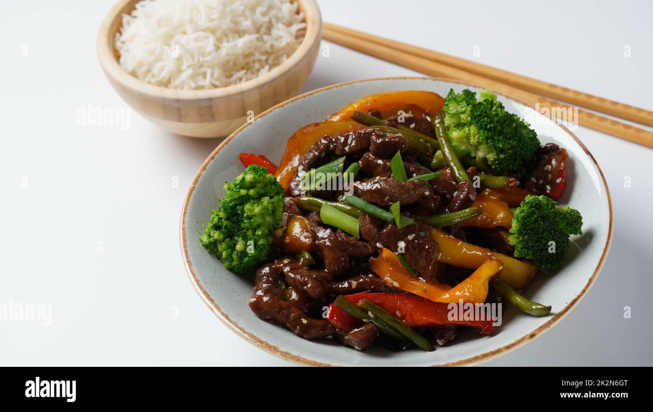 Mongolian meat in sauce with rice. Mongolian barbecue with meat and vegetables in Thai restaurant Stock Photo