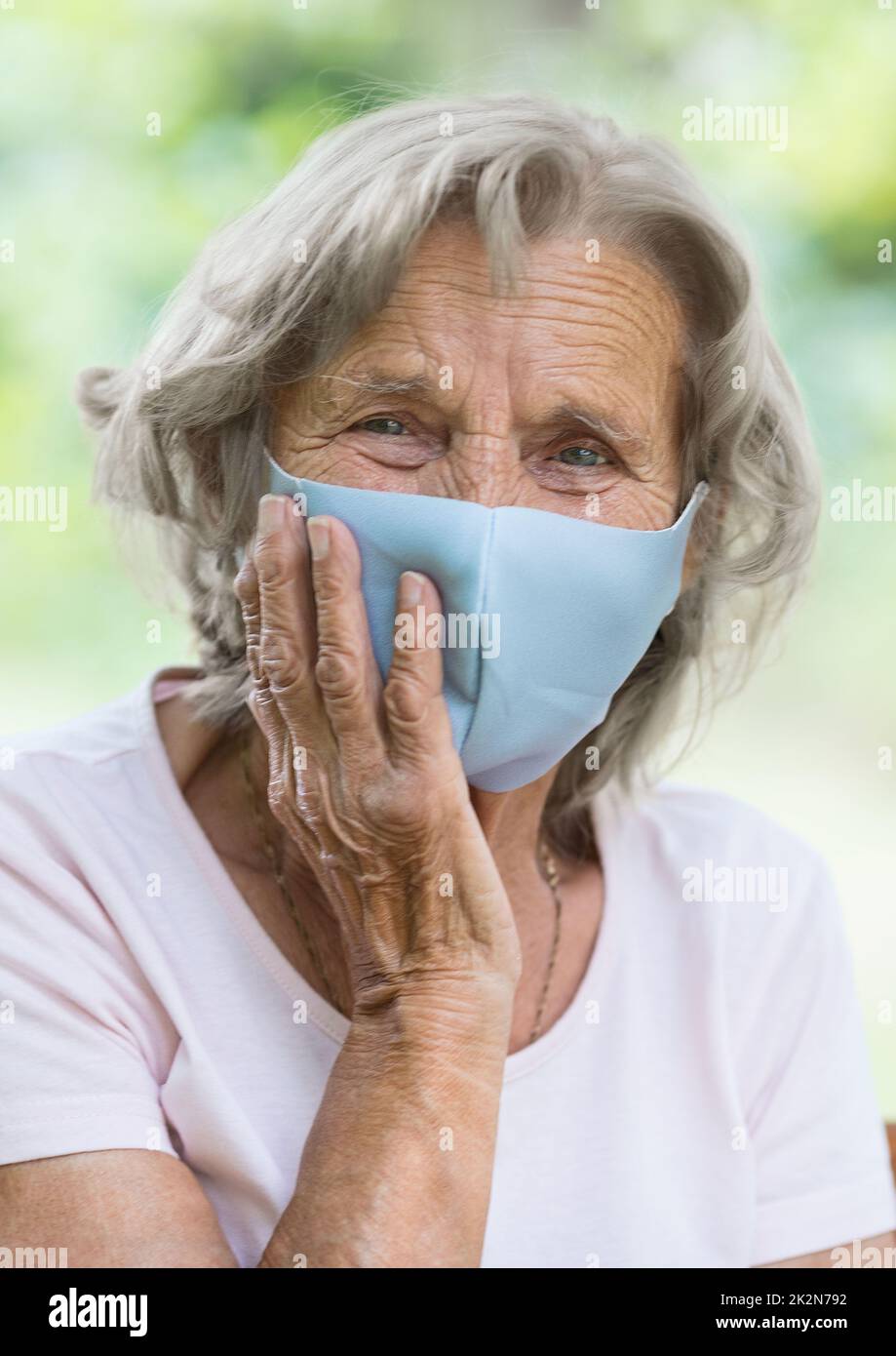 Elderly woman wearing a protective face mask against viruses Stock ...
