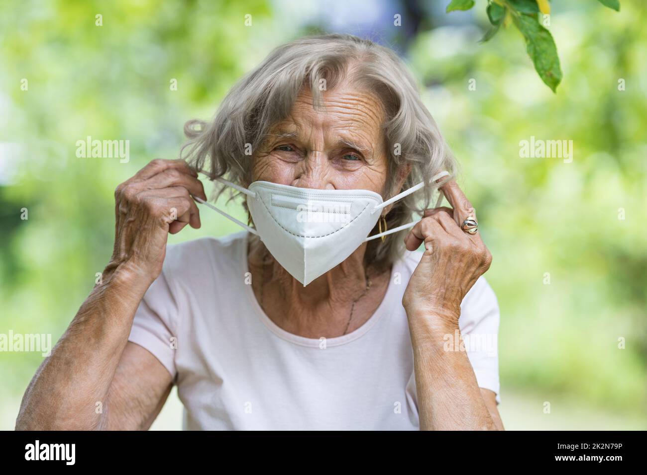 Woman putting on facemask hi-res stock photography and images - Alamy