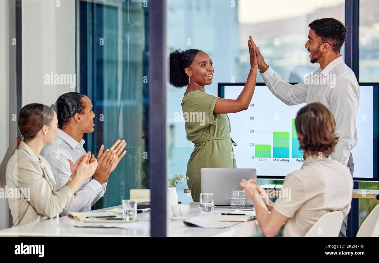By failing to prepare, you are preparing to fail. Shot of a young man and woman high fiving one another in a meeting in a modern office. Stock Photo