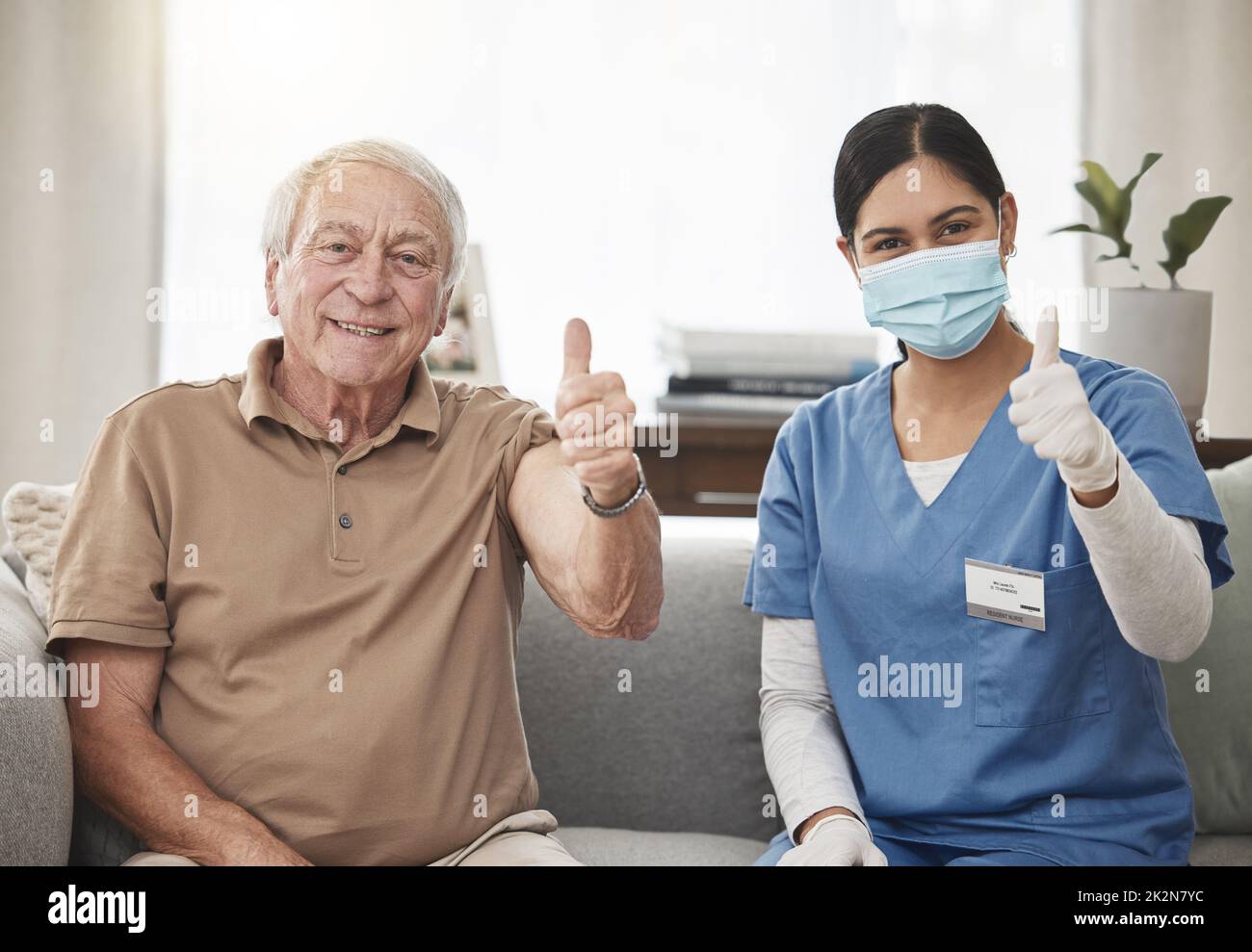 Protect yourself and get vaccinated. Shot of an elderly man and a young female nurse showing a thumbs up during a checkup at home. Stock Photo