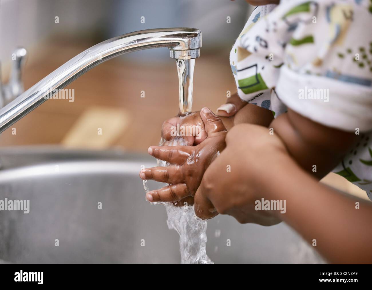 Keeping our hands clean. Shot of an unrecognizable child and parent washing their hands at home. Stock Photo