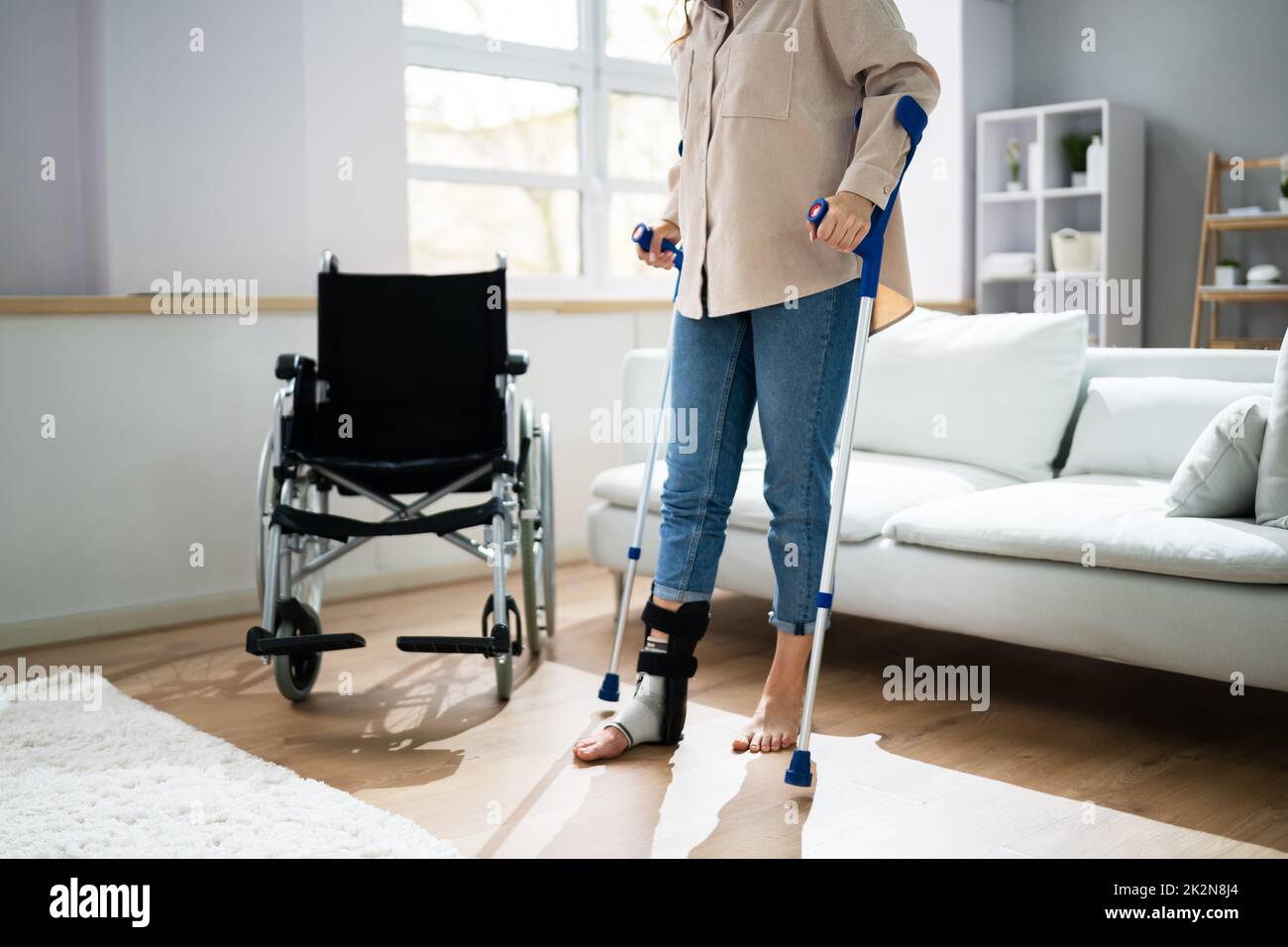 Hurt Leg Using Crutches Near Wheelchair Stock Photo Alamy