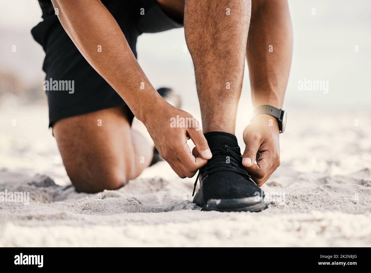 I talk the talk and I run the run. Cropped shot of an unrecognizable man tying his shoelaces while out for a workout. Stock Photo