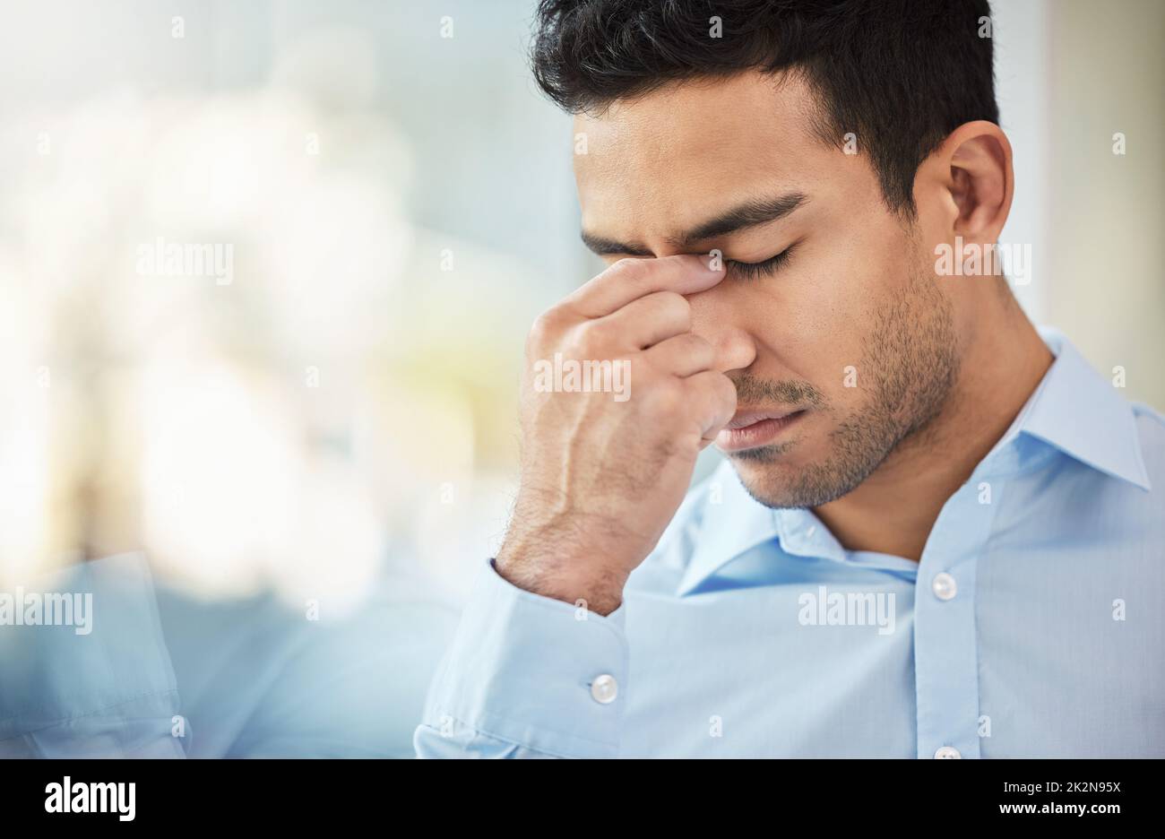 Sometimes challenges arise last minute. Shot of a businessman experiencing a headache at work. Stock Photo