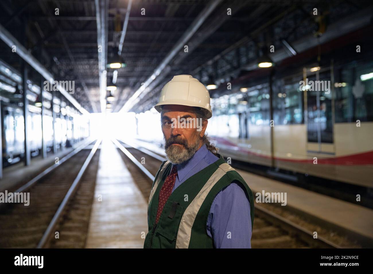 Portrait male transit manager on tracks in maintenance facility Stock Photo