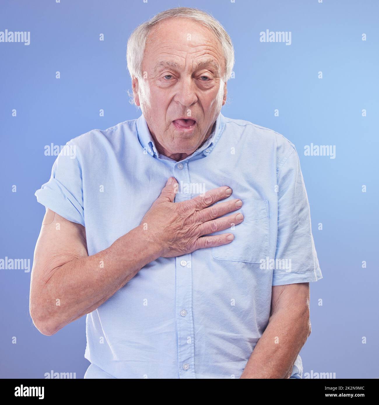 Shortness of breath could shorten your life, get it checked. Studio shot of a senior man experiencing chest discomfort against a blue background. Stock Photo