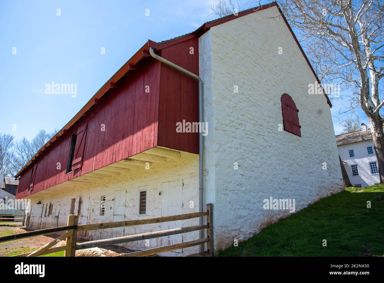 Colonial American whitewashed stone barn with red wood trim Stock Photo