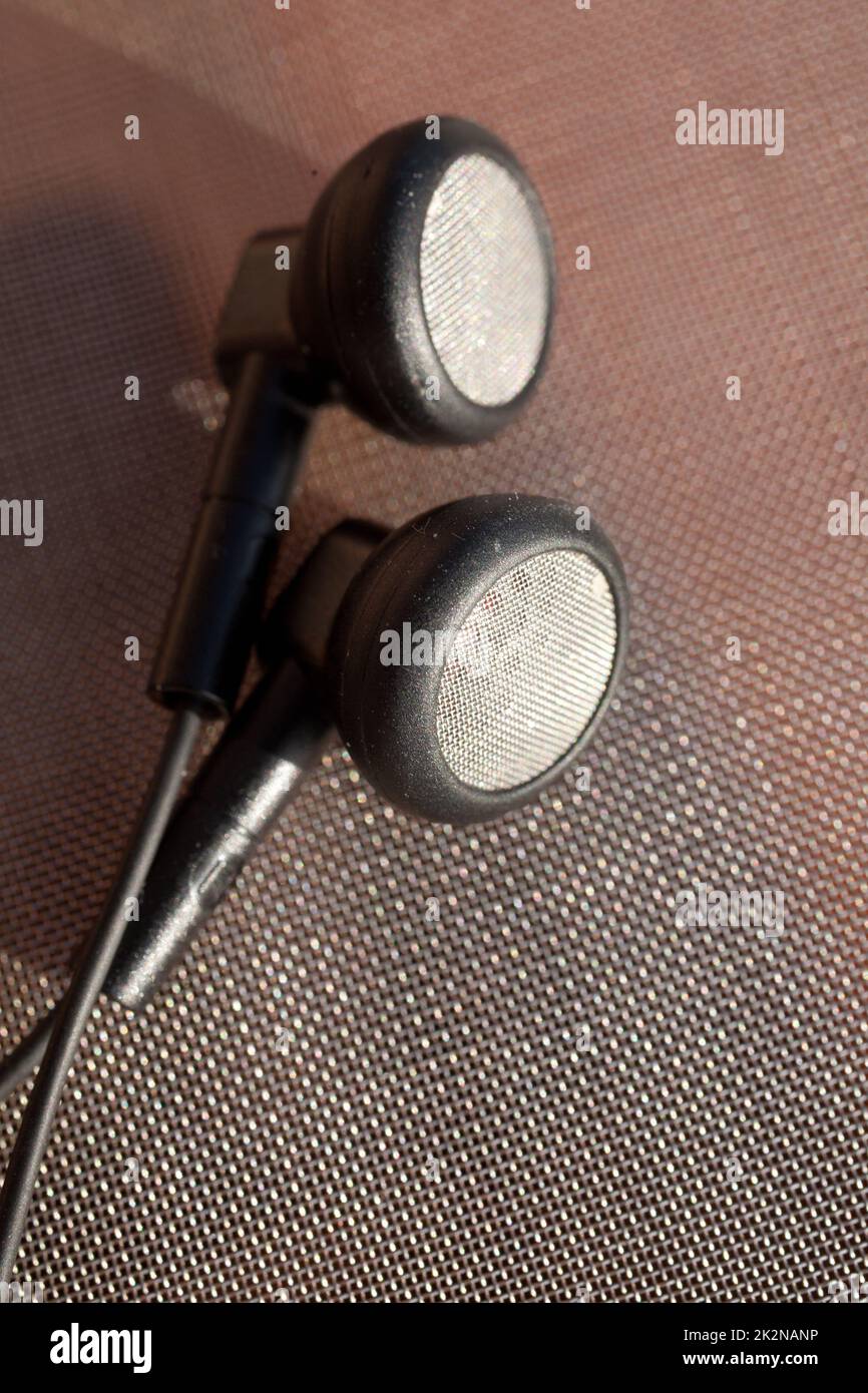 black anonymous earphones on a metallic network Stock Photo