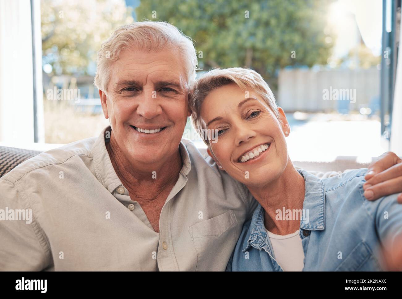 Retirement portrait of happy senior couple relax on a sofa together in their living room or summer holiday house. Smile, affection and love with Stock Photo