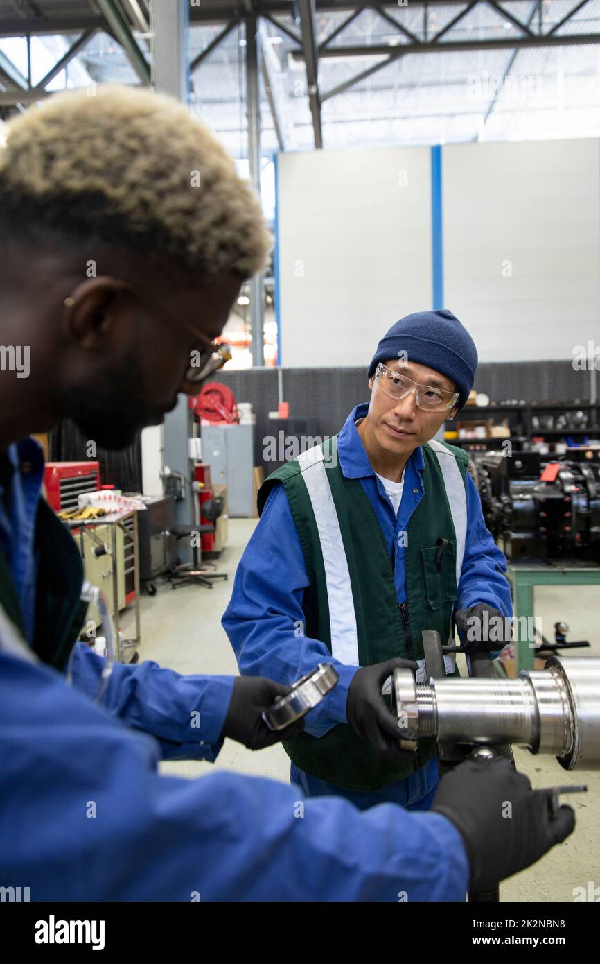 Male transit worker examining part in maintenance facility Stock Photo