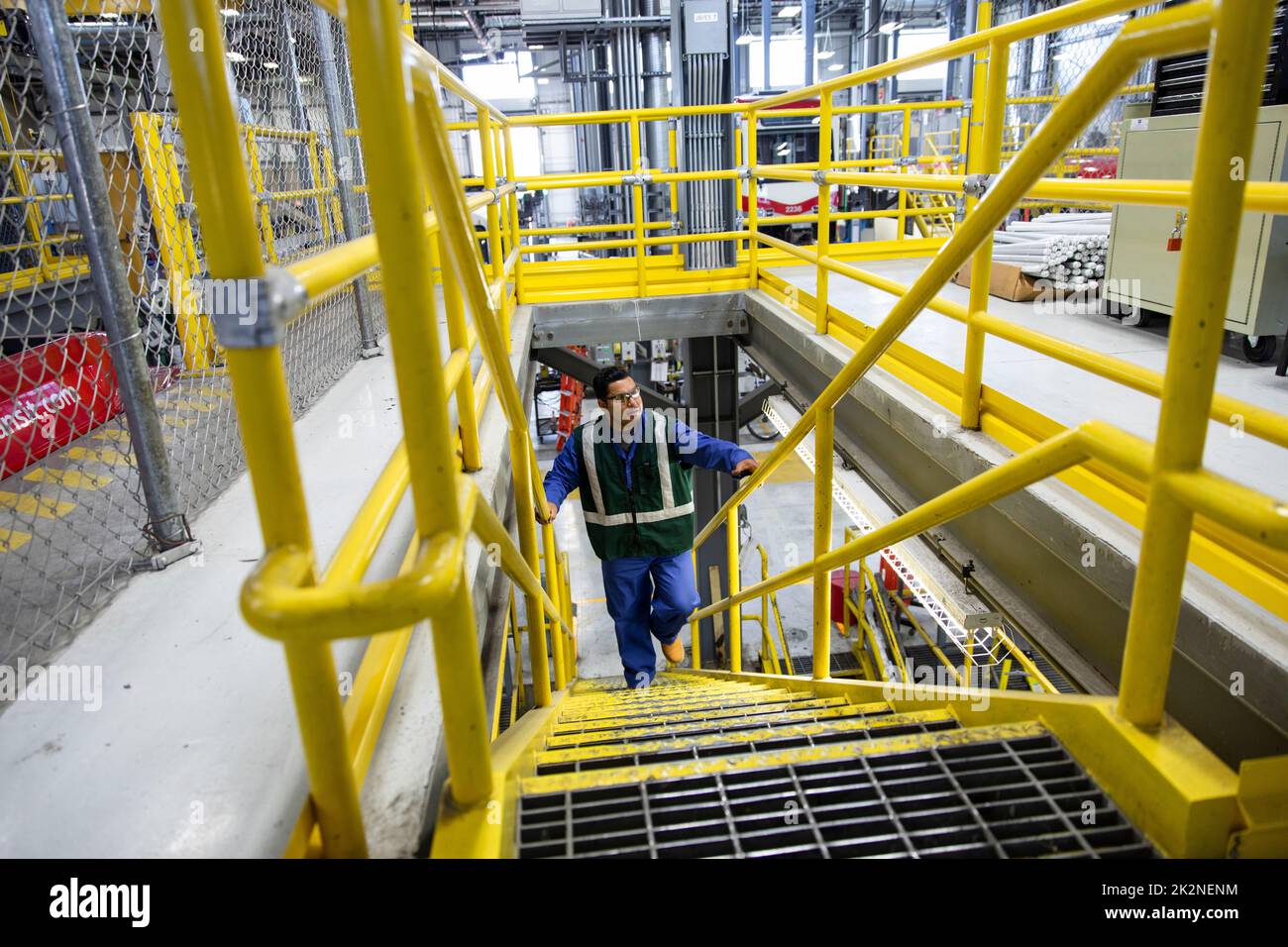 Male transit worker climbing steps in maintenance facility Stock Photo