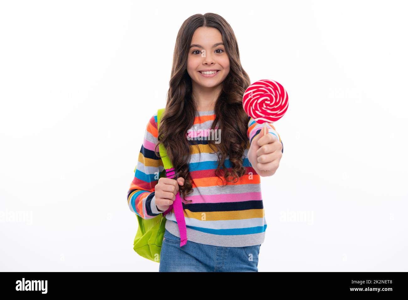 Funny child with lollipop over white isolated background. Sweet childhood life. Teen girl with yummy caramel lollipop, candy shop. Happy girl face Stock Photo