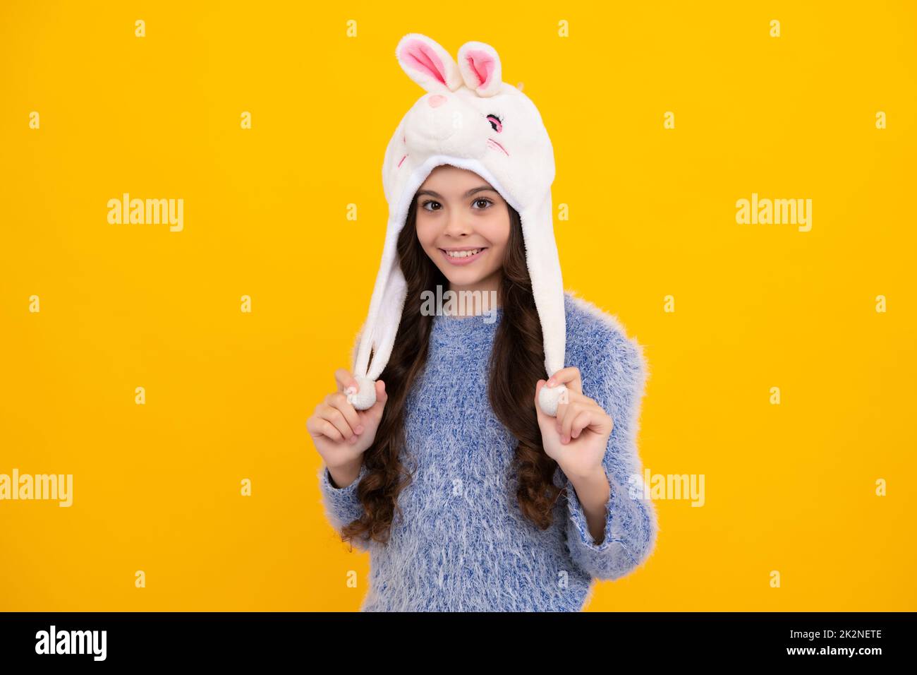 Bunny warm hat. School girl in winter clothes and warm hat. Winter holiday vacation. Child fashion model. Happy teenager, positive and smiling Stock Photo