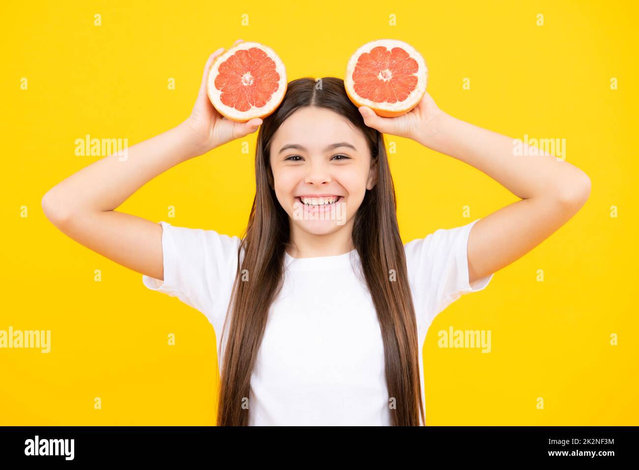 Happy teenager girl in t-shirt hold grapefruit orange, kids fruits vitamin. Happy teenager portrait. Smiling girl. Stock Photo